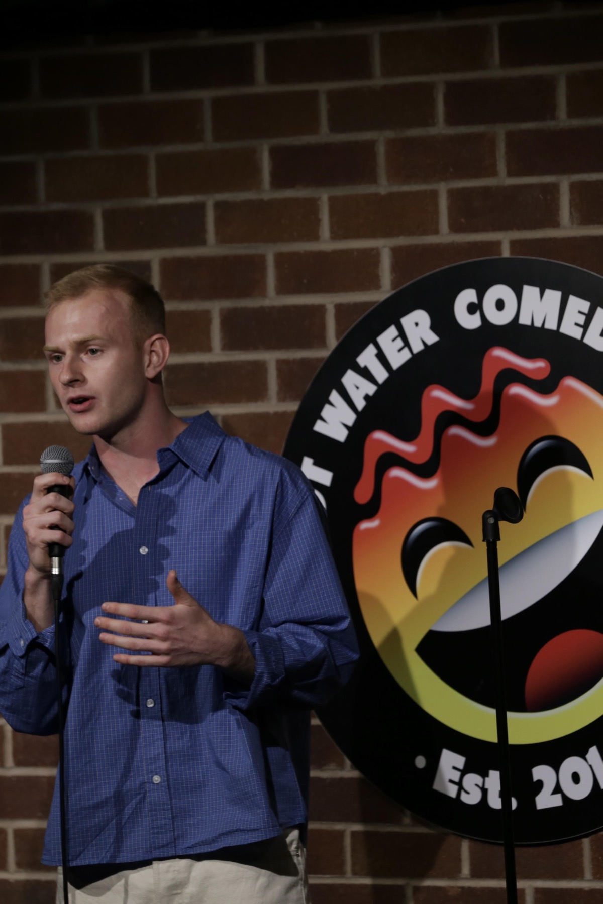 Josh Murphy performing stand-up on stage.